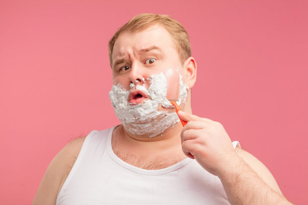 图片中是一个满脸剃须泡沫的震惊男子。看相机。图片下载