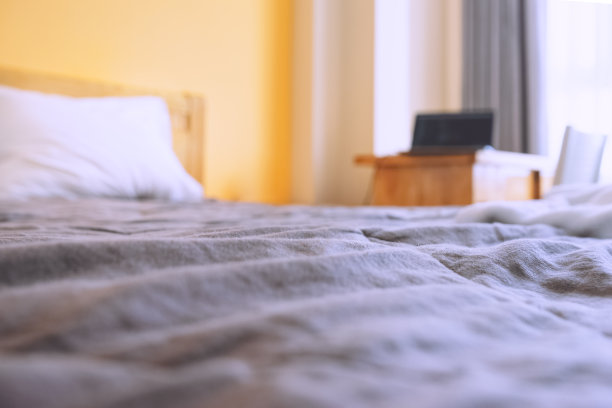 一张模糊的照片，一张桌子上放着笔记本电脑的床图片下载