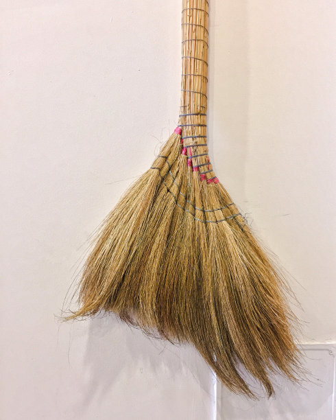 木质扫帚在墙上的背景。图片下载