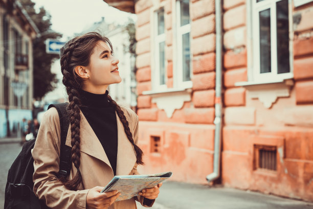 年轻的欧洲游客用地图在外国城市愉快而兴奋地行走。图片下载