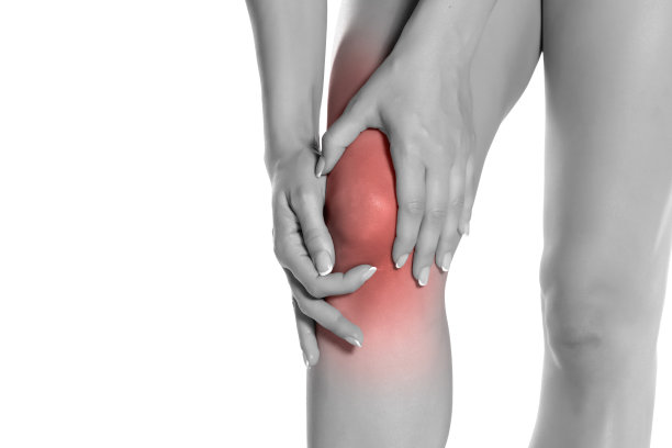 女人抱着她痛苦的膝盖在白色的背景图片下载