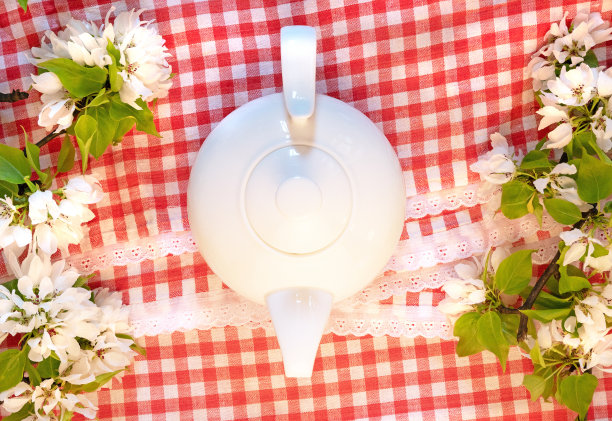 白茶壶、苹果树、花枝、花边、红格子的意大利台布平铺。花蕾俯视图模板图片下载