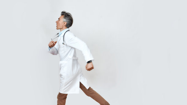 随时准备提供帮助。在演播室的灰色背景下，戴着听诊器围着脖子的成熟男性医生的侧视图图片下载