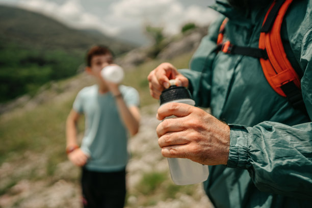 父亲和儿子在徒步旅行喝水图片下载