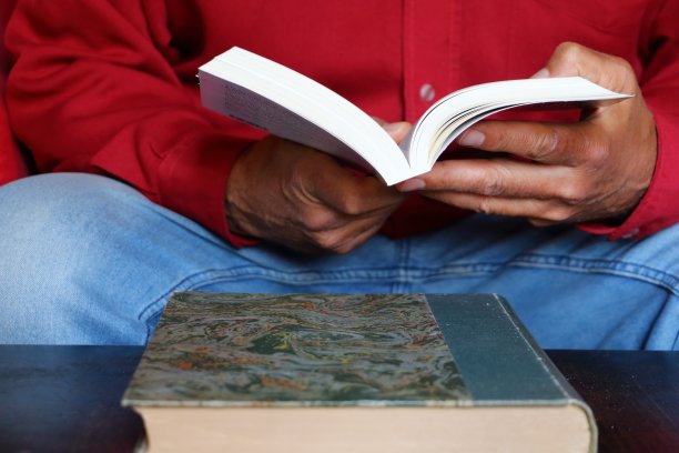 一个穿红衬衫的男人在看书图片下载