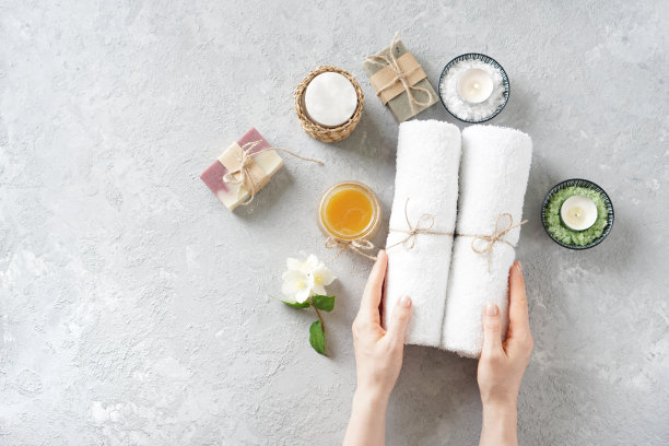 为完美的有机水疗做准备。女孩手中拿着白色的毛巾在水疗产品中。前视图。图片下载