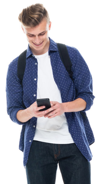 白人少年穿着裤子站在白色背景前使用手机图片下载