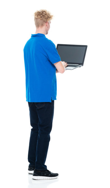 白人年轻男性穿着牛仔裤站在白色背景下使用笔记本电脑图片下载