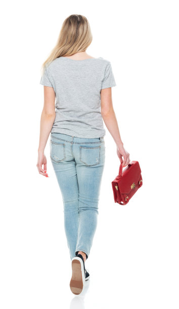 z一代的少女穿着t恤，拿着公文包走在白色背景前图片下载