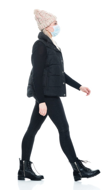 白种年轻女子身穿马甲，无袖行走在白色背景前图片下载