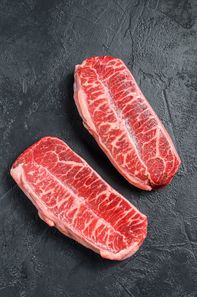 生牛排干熟。黑色背景。俯视图图片下载