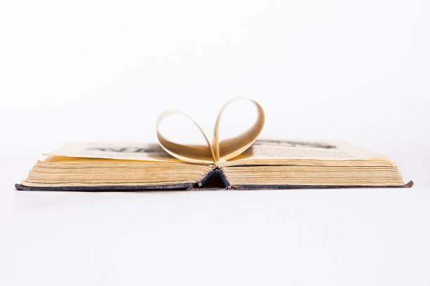 打开一本在白色背景上有心形图案的旧书图片下载