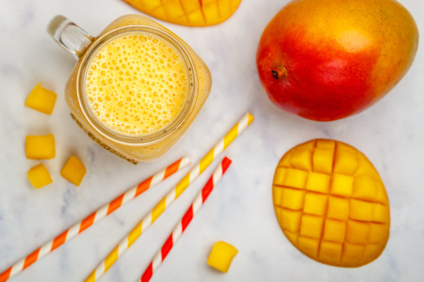 冰沙或奶昔由新鲜芒果、酸奶或牛奶和冰块制成，放在大理石桌子上。健康维生素饮料的概念。选择性聚焦，俯视图图片下载
