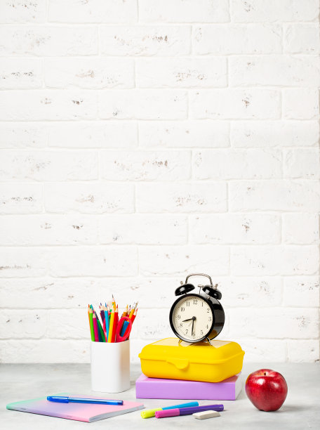 9月1日返校。闹钟，书，笔记本，铅笔和饭盒在桌子上。图片下载