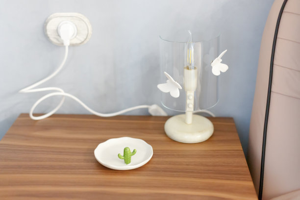 床头柜上的灯已经插上了电源。图片下载