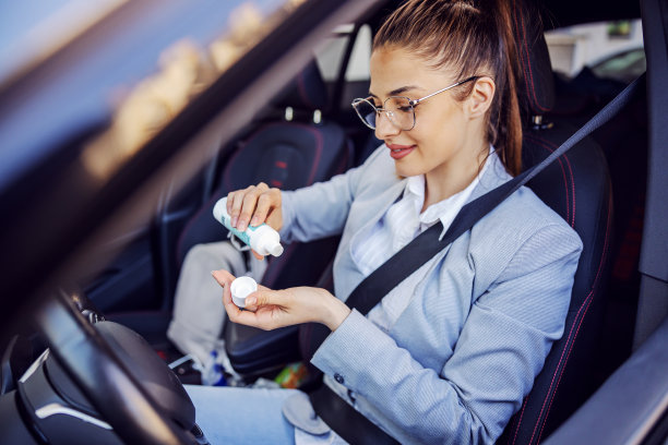 年轻迷人的女商人穿着智能休闲使用消毒产品清洁她的手。保护形成冠状病毒概念。图片下载