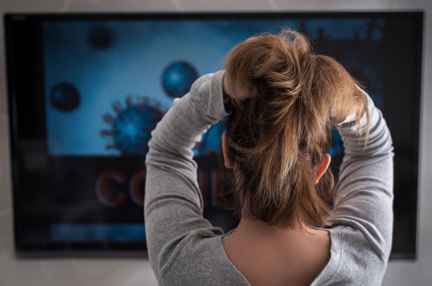 一个女人在看一个关于奥维德分发的电视节目。图片下载