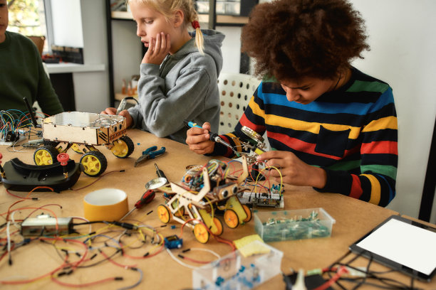 不可能只需要多花一点时间。年轻的工程师使用烙铁连接芯片和电线。面向小学生的机器人和软件工程。孩子们的发明和创造力图片下载