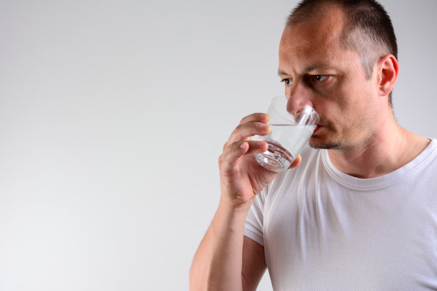 英俊的中年男人在喝水。图片下载