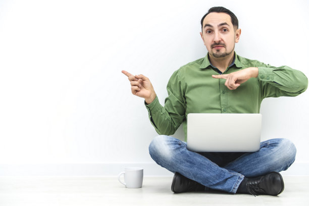 演示的概念。聪明的商人拿着笔记本电脑，指着白色墙壁背景下的关键字拷贝空间。图片下载