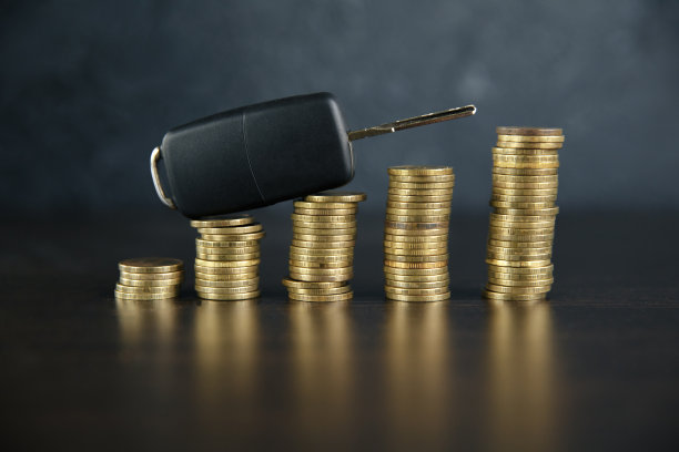 特写汽车钥匙前堆放在木桌上的硬币图片下载