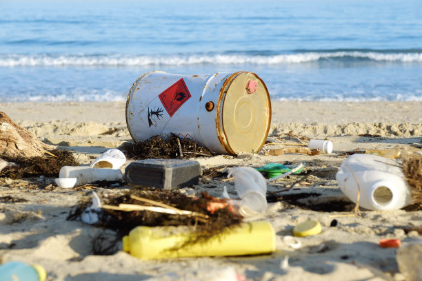 垃圾洒在大城市的海滩上。空的用过的脏塑料瓶。有毒的生锈的桶。肮脏的黑海。环境污染。生态问题。有毒废物，化学工业。移动的波图片下载