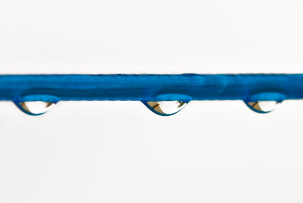 雨后，在一个明亮的背景前，一条有许多雨滴的蓝色衣服线。复古洗衣服的方式。图片下载