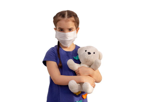 一个棕色头发的小女孩戴着白色医用面具，穿着蓝色裙子，抱着一只白色的泰迪熊图片下载