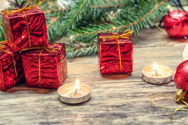 红色的迷你礼物在杉木树枝、蜡烛之间的木制背景中。美丽的圣诞背景，贺卡与复制空间。从顶部俯瞰的照片。图片下载