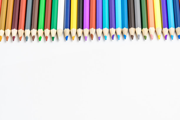 一组混合的彩色铅笔排成一行，孤立在白色上，儿童学校或办公供应商用柔焦从侧面拍摄，有文字空间图片下载