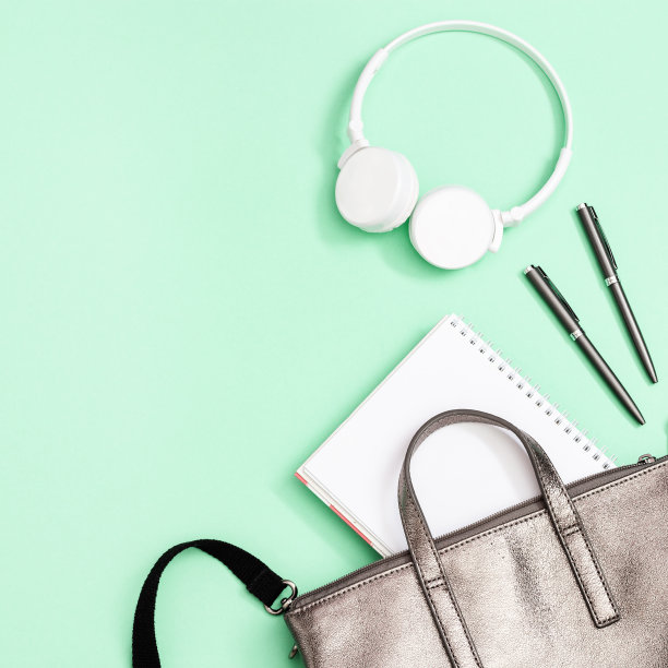 书包和学习用品，笔记本，笔，白色耳机在新薄荷背景。前视图。回到学校的概念。图片下载