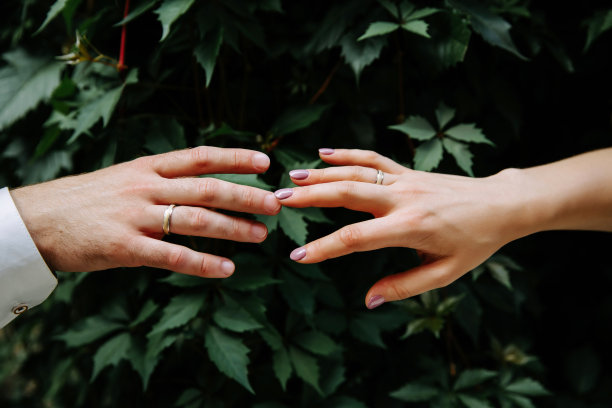 男人和女人的手在花园里互相触摸。婚礼当天的概念图片。图片下载