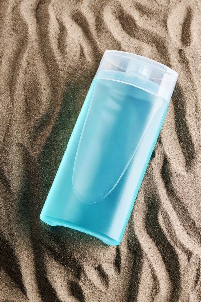 空白产品蓝色新鲜管或瓶在沙子背景。垂直的影棚拍摄。设计的模型。图片下载