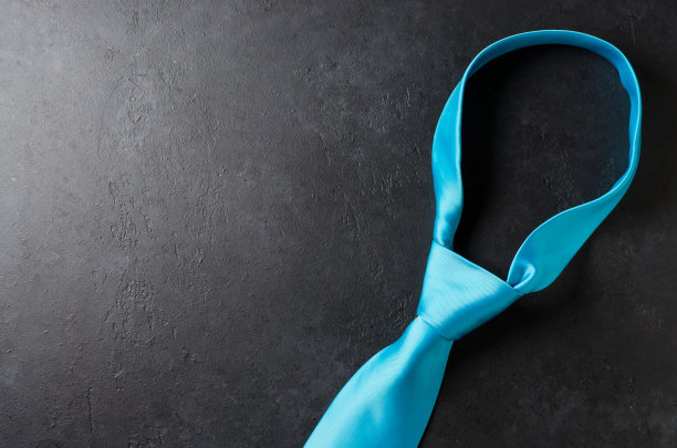 黑色混凝土背景上的蓝色男士领带。一个成功的现代人的概念。本空间图片下载