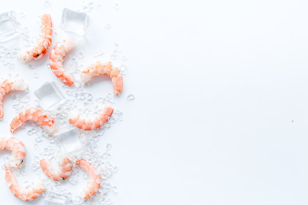 虾-去皮，与冰-在白色的桌子框架空间的文字图片下载