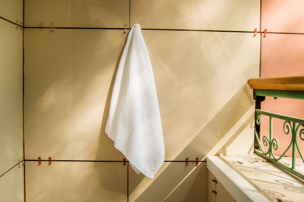 白色毛巾布毛巾挂在阳台或阳台的墙上，夏日晴天图片下载