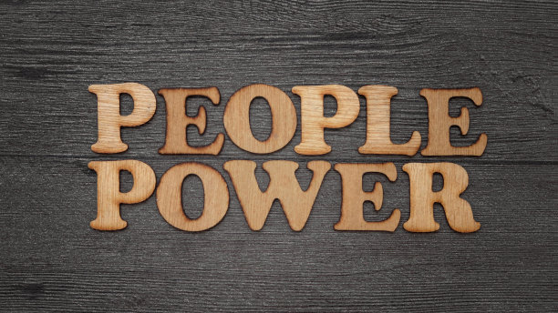 人民的力量。动机的商业单词引用，木制字母排版概念上的黑色背景图片下载