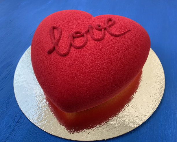 蓝色的木桌上放着红色天鹅绒蛋糕。爱的象征图片下载