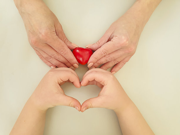 孩子和妈妈的手握着一颗心图片下载