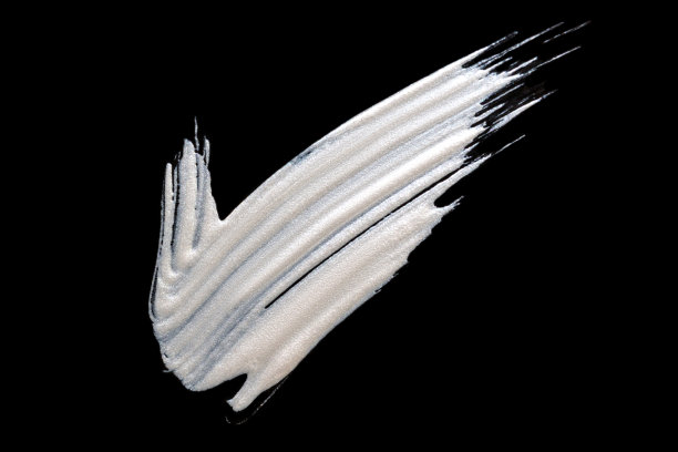 粉底为脸部孤立的黑色背景。涂抹高光或发光霜底漆。化妆品样品弄脏了图片下载