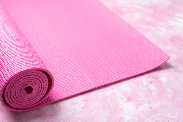 粉色背景的瑜伽垫。瑜伽的设备。健康生活方式、运动、冥想和放松的概念。俯视图图片下载