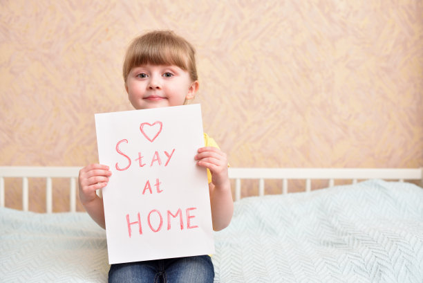 待在家里-一个在纸上题词的女孩的手。2019冠状病毒病大流行期间图片下载