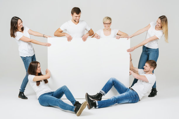 六个快乐的朋友穿着蓝色牛仔裤举着一个牌子图片下载