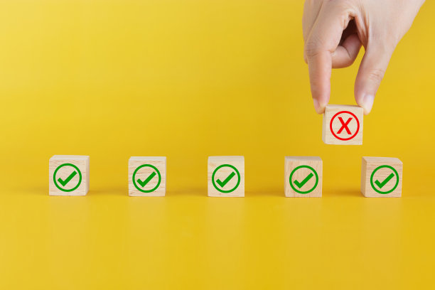 手指挑起木质立方体，X标记向上，创造彼此之间的空间。新常态概念下的社交距离或身体距离，避免疫情期间传播病菌图片下载