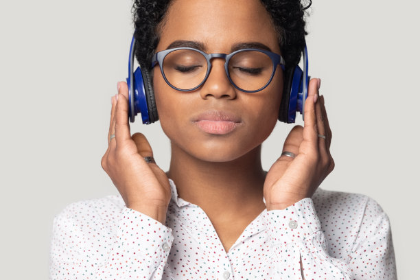 美丽的非洲女人戴着耳机听最喜欢的音乐工作室拍摄图片下载