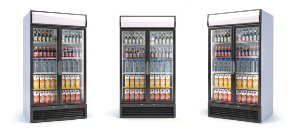 冰箱与饮料隔离在白色。一套展示冰箱与水，啤酒和苏打在杂货店。图片下载