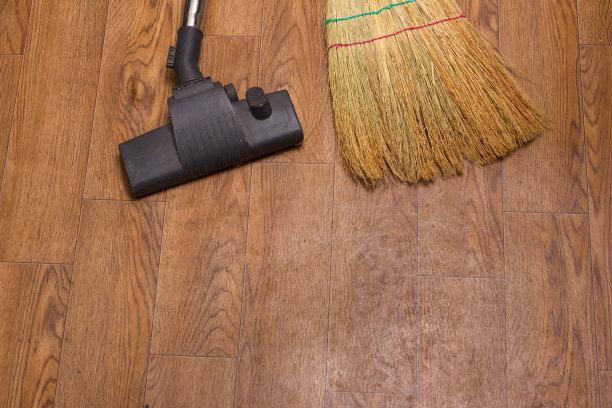 在油毡的背景上有吸尘器、刷子和扫帚。图片下载