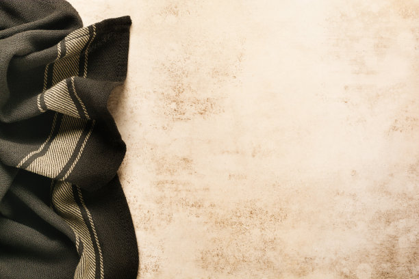 浅棕色的混凝土纹理，表面覆有棉质厨房餐巾或毛巾和烤盘。抽象的背景。空间背景副本。图片下载