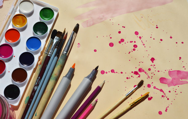 供应绘画。水彩颜料，画笔，铅笔，水彩标记在一个浅的背景紫色斑点。副本的空间。横幅。图片下载