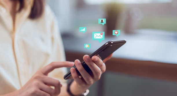 通信网络的概念。女人用手按智能手机，手机上显示电子邮件图标。图片下载